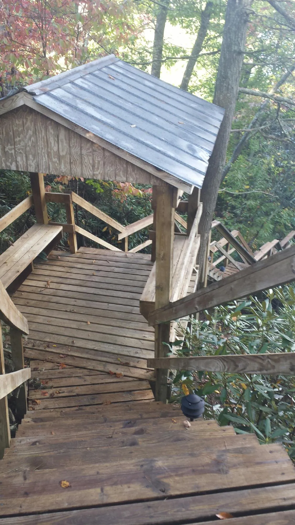 Metal roofed shelter over wooden steps on a wooded walkway — Skylight Repair & Installation work by our crew in Newburgh